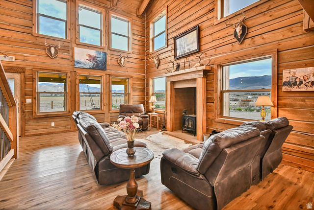 544 East 600 North, Unit 1 Joseph, UT 84739 - Photo 6 of 65 Vaulted living space featuring extensive wood-finish wall paneling, wood-finish flooring, a wood-burning stove, and multiple large windows with mountain scenery