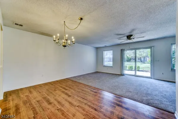 a view of a livingroom with a chandelier fan and a window
