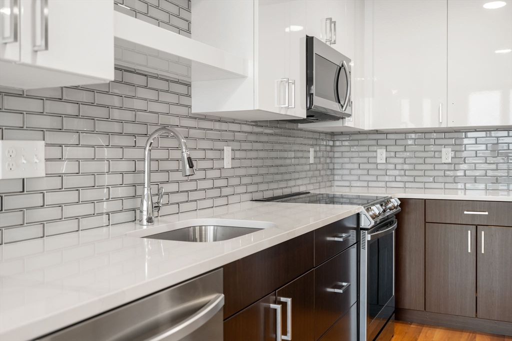 10 Taber Street, Unit 503 Boston, MA 02119 - Photo 18 of 21 a view of a kitchen counter space a sink and wooden floor