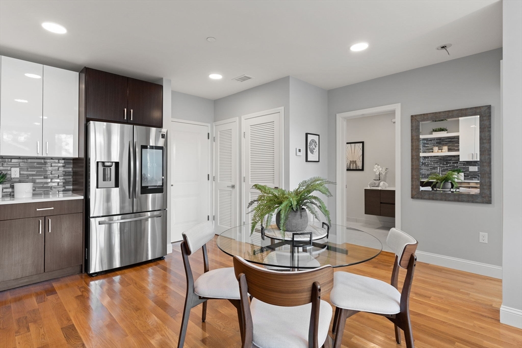 10 Taber Street, Unit 503 Boston, MA 02119 - Photo 5 of 21 a kitchen with granite countertop stainless steel appliances a refrigerator and a table chair