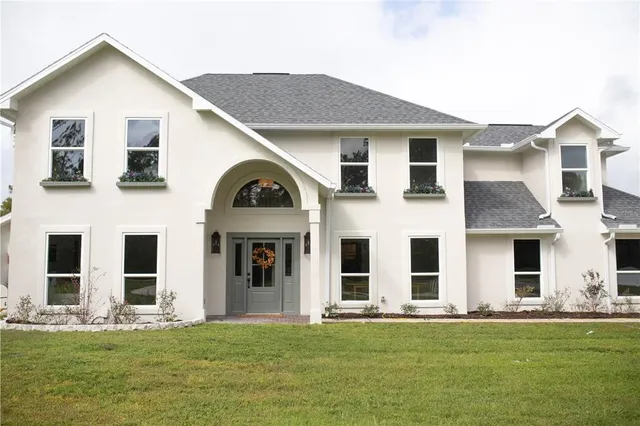 a view of a white house with yard and front view of a house