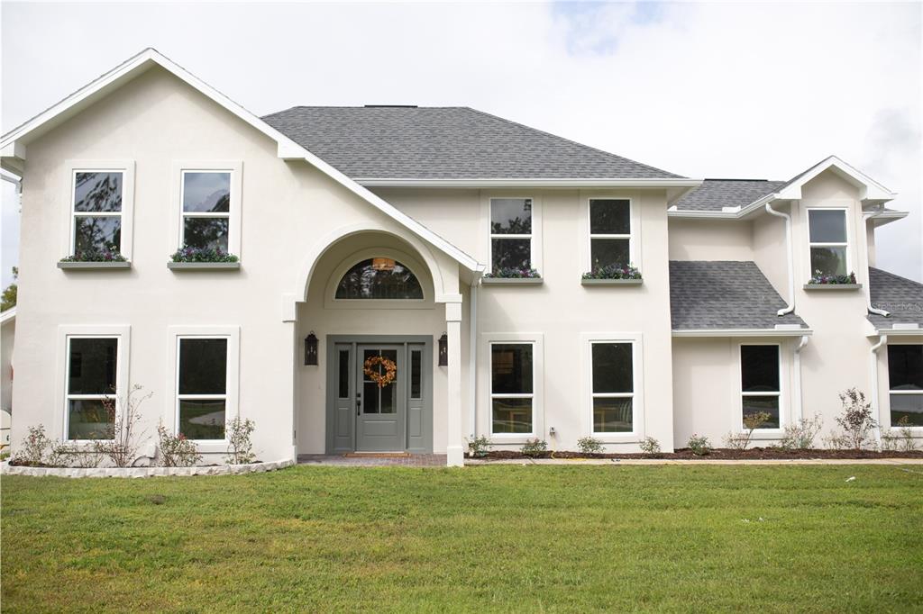 320 Rodeo Road Ormond Beach, FL 32174 - Photo 3 of 53 a view of a white house with yard and front view of a house