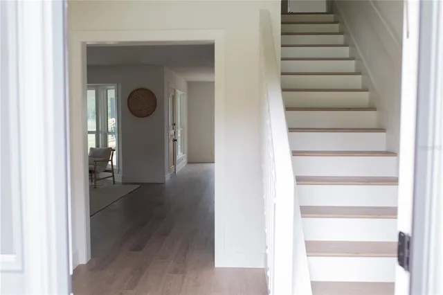 a view of a hallway with wooden floor and entryway
