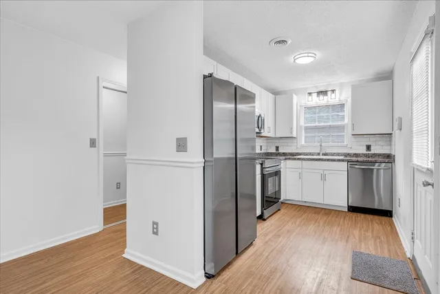 a kitchen with white cabinets and white appliances