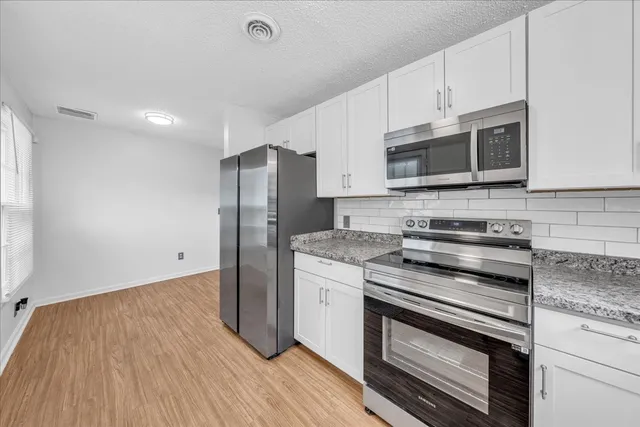 a kitchen with granite countertop wooden cabinets and stainless steel appliances