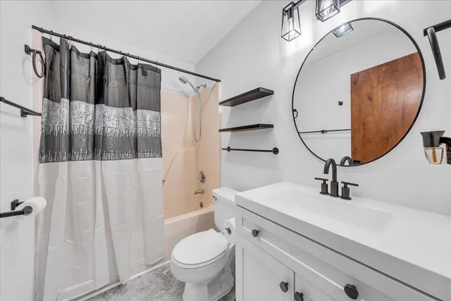 a bathroom with a sink a toilet and a mirror