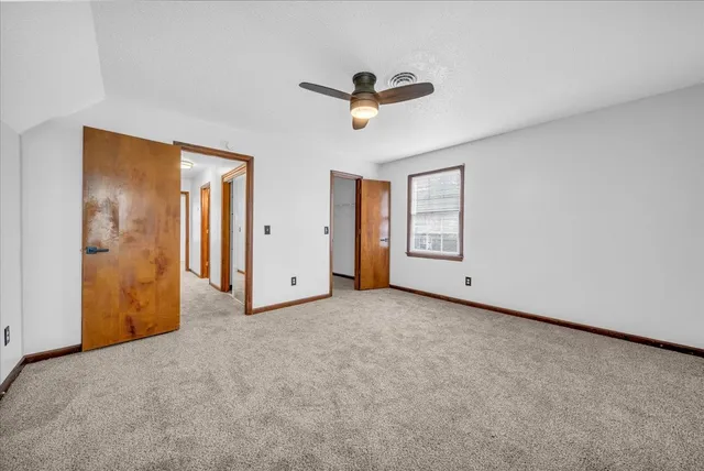 a view of a livingroom with a ceiling fan and window