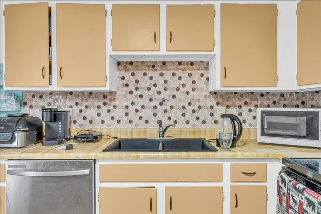 a kitchen with a sink and a stove next to a window