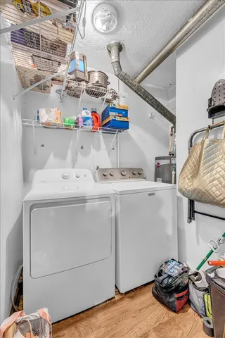 a utility room with stainless steel appliances and a wooden floor