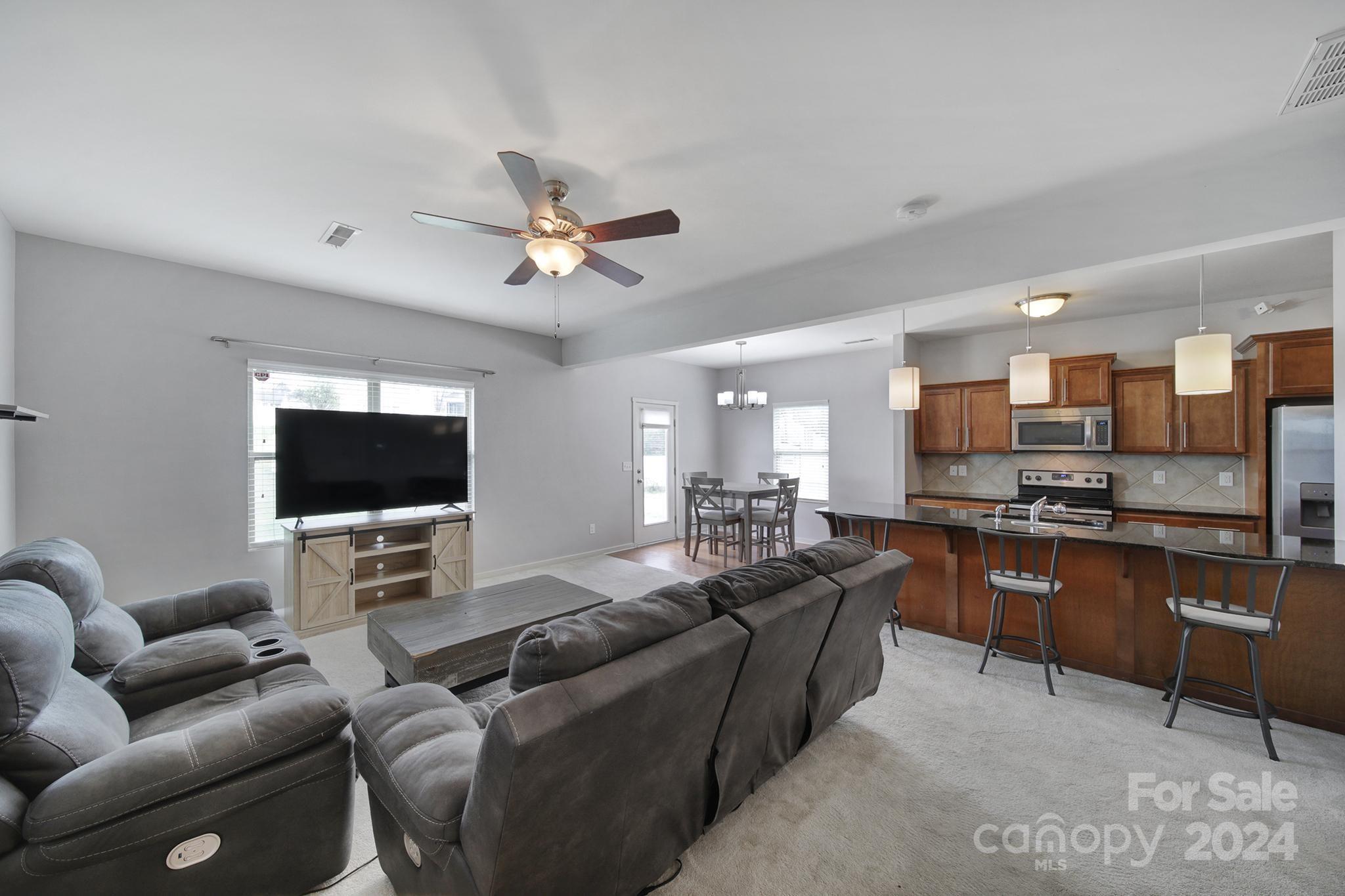 1539 Logan Patrick Court Gastonia, NC 28052 - Photo 2 of 26 a living room with furniture kitchen view and a flat screen tv