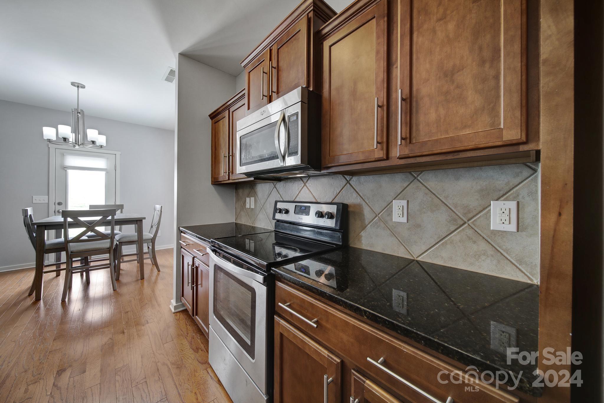 1539 Logan Patrick Court Gastonia, NC 28052 - Photo 10 of 26 a kitchen with stainless steel appliances granite countertop a stove a sink and a microwave