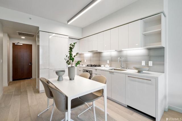 a kitchen with a white cabinets and chairs