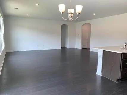 a view of a room with wooden floor and chandelier