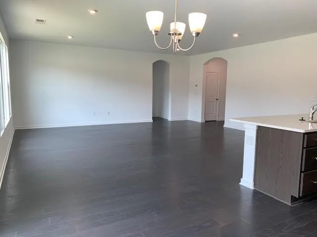 a view of a room with wooden floor and chandelier