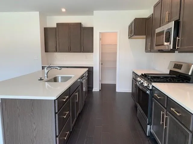 a kitchen with stainless steel appliances granite countertop a sink and a stove