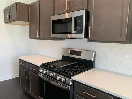 a kitchen with granite countertop a stove and a microwave