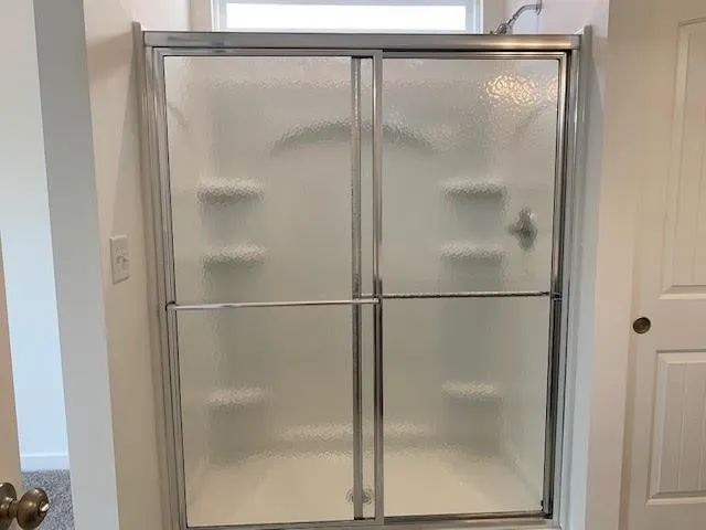a bathroom with a glass shower door