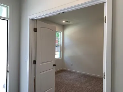 a view of an empty room with windows and closet