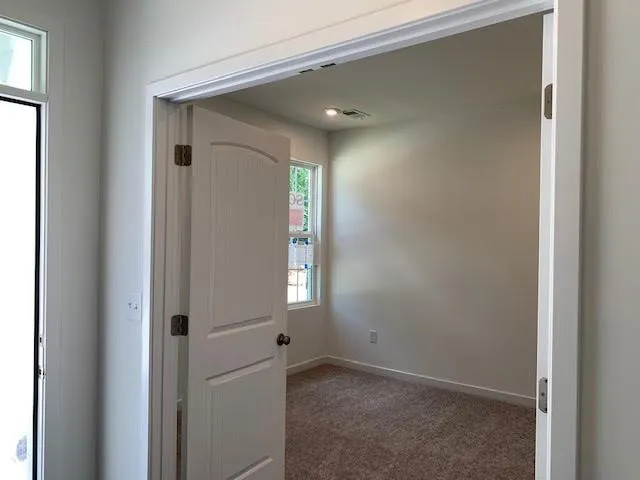 a view of an empty room with windows and closet