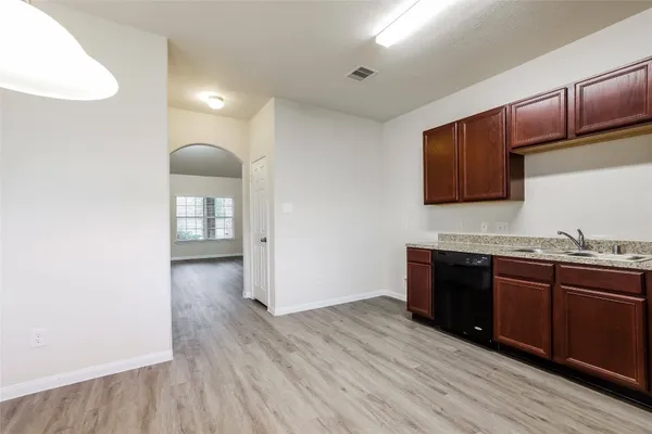 a kitchen with wooden floors and wooden cabinets