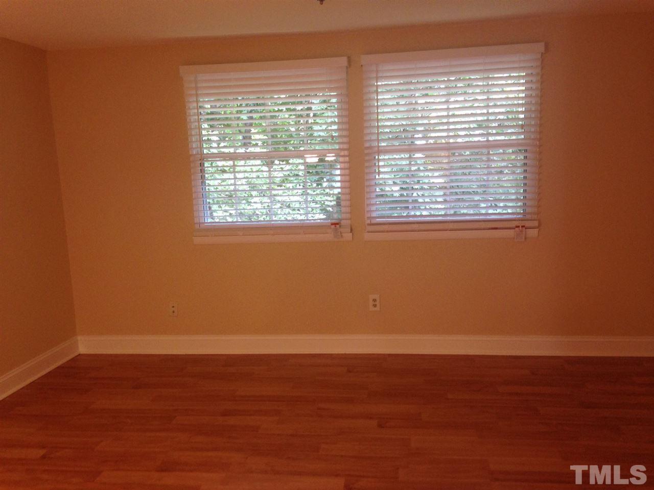 7752 Sandra Lane Raleigh, NC 27615 - Photo 4 of 6 a view of an empty room with wooden floor and a window