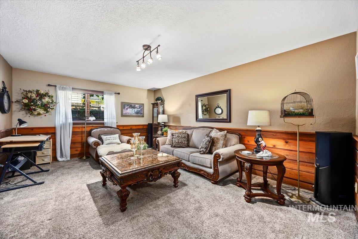 956 Bitterroot Place Twin Falls, ID 83301 - Photo 14 of 48 Carpeted living area featuring wood paneling, neutral-toned walls, and a window with natural light