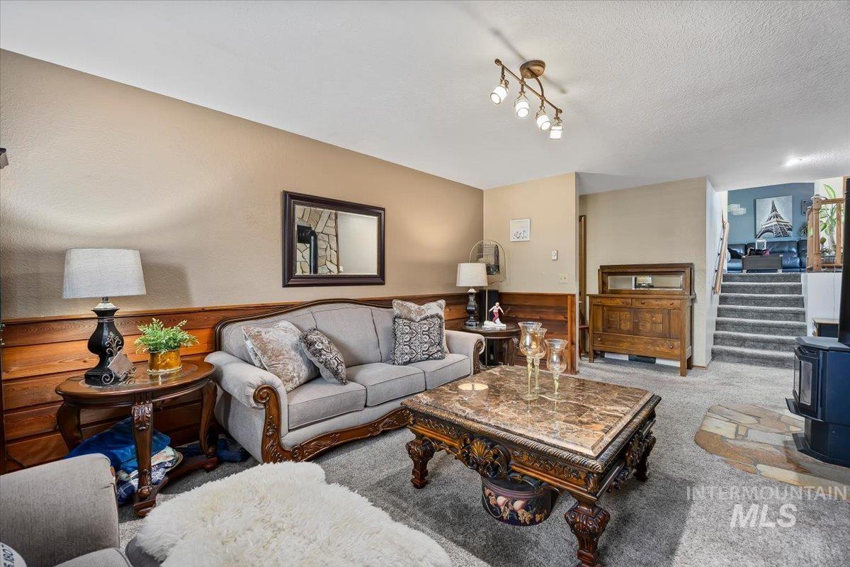 956 Bitterroot Place Twin Falls, ID 83301 - Photo 17 of 48 Living area featuring wood paneling, neutral wall paint, recessed lighting, and carpeted flooring with a stone-finish hearth