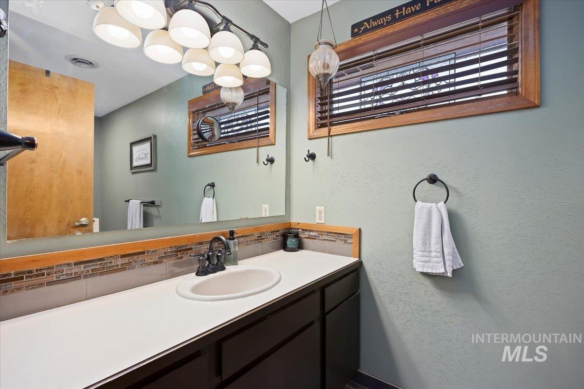 956 Bitterroot Place Twin Falls, ID 83301 - Photo 22 of 48 Vanity with an integrated sink, a dark wood-finish cabinet, and a white countertop