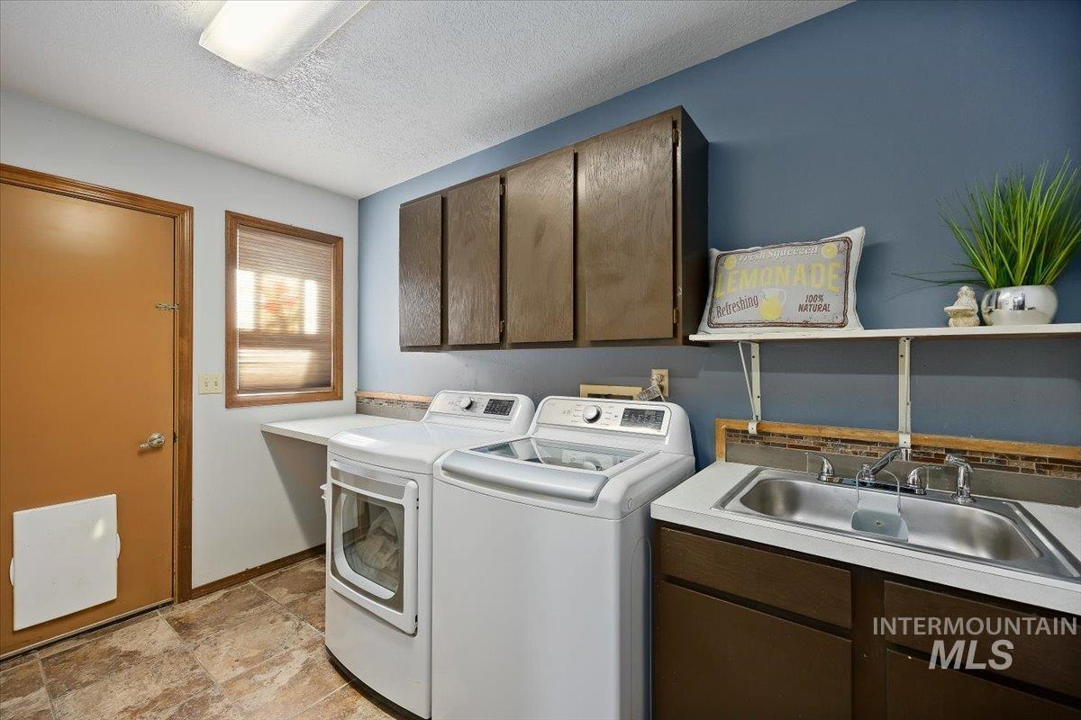956 Bitterroot Place Twin Falls, ID 83301 - Photo 27 of 48 Laundry room featuring a utility sink, brown cabinetry, and tile flooring