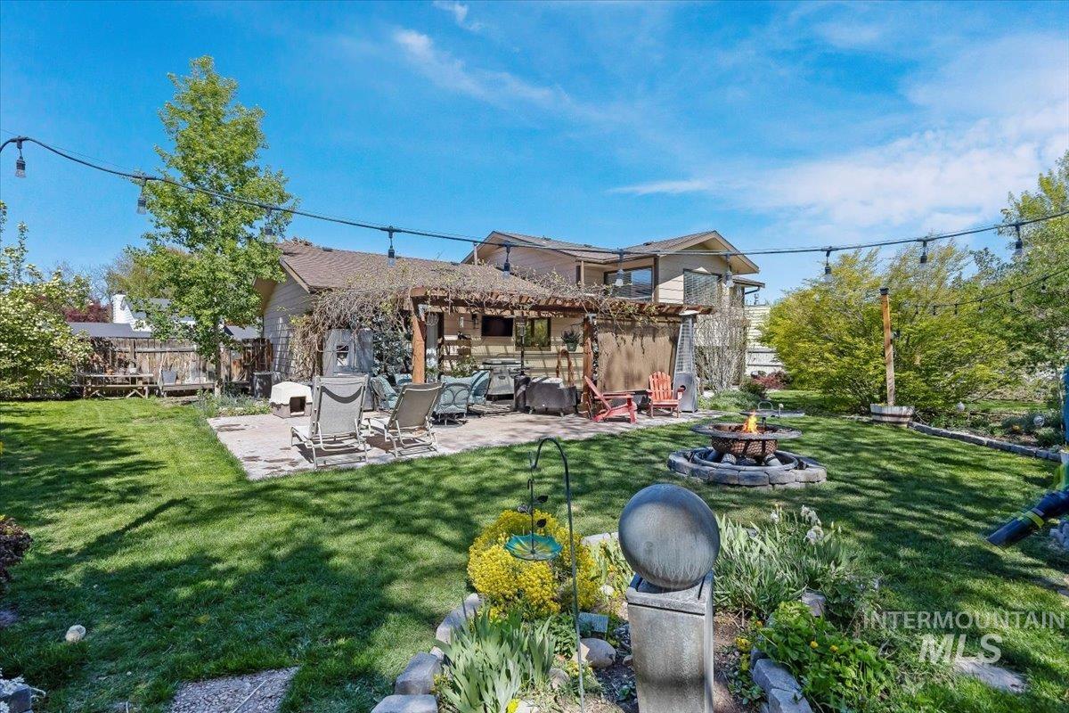 956 Bitterroot Place Twin Falls, ID 83301 - Photo 30 of 48 Expansive backyard featuring a stone patio, a wooden pergola, and a built-in fire pit with a stone surround
