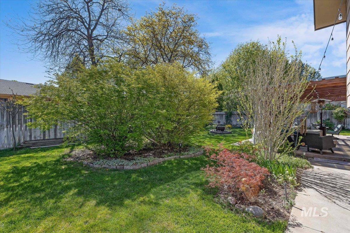 956 Bitterroot Place Twin Falls, ID 83301 - Photo 35 of 48 Expansive outdoor space featuring a manicured lawn, established shrubbery, and a concrete patio