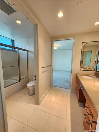 a bathroom with a granite countertop sink a toilet and a mirror