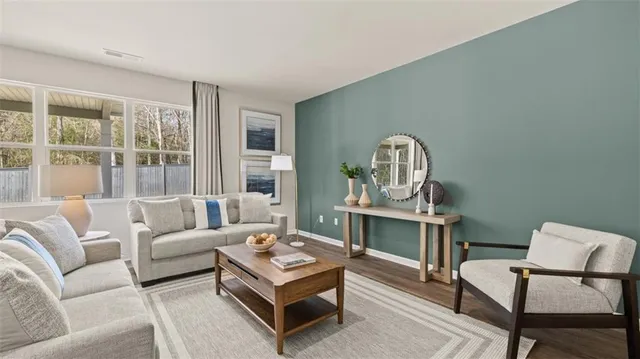 a living room with furniture and a wooden floor