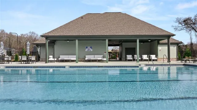 a view of a house with swimming pool and sitting area