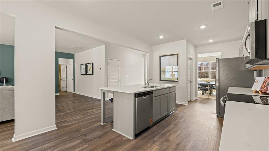 398 Bullock Pass Jefferson, GA 30549 - Photo 5 of 44 a large kitchen with stainless steel appliances granite countertop a lot of counter space and wooden floor