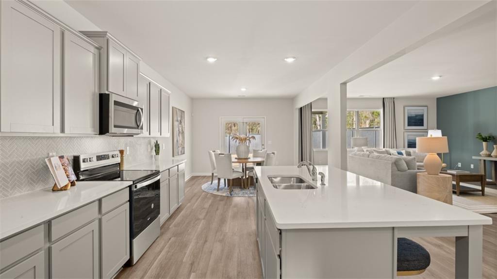 398 Bullock Pass Jefferson, GA 30549 - Photo 6 of 44 a kitchen with stainless steel appliances a sink dishwasher a stove top oven a refrigerator with island and chairs