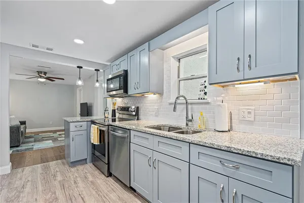 a kitchen with granite countertop cabinets stainless steel appliances a sink and a counter top space