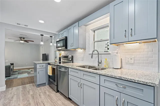 a kitchen with granite countertop cabinets stainless steel appliances a sink and a counter top space