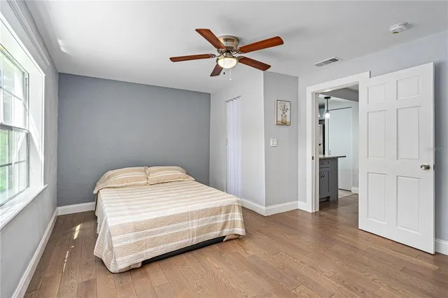 a bedroom with a bed and a ceiling fan