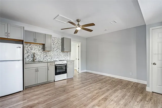 a kitchen with a refrigerator and white cabinets