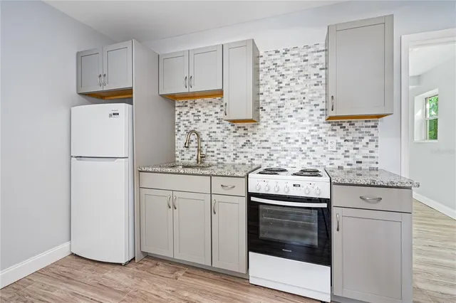 a kitchen with stainless steel appliances white cabinets and white appliances