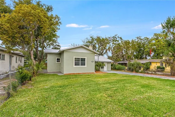 a front view of a house with a yard and trees