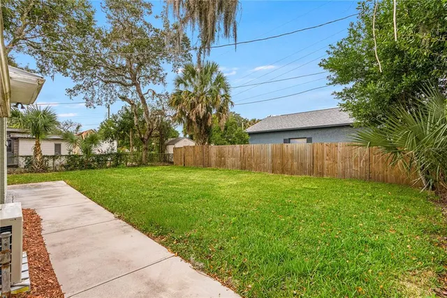 a view of a backyard with wooden fence