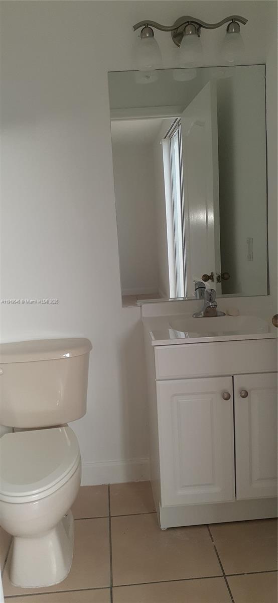 8091 West 36th Avenue, Unit 3 Hialeah, FL 33018 - Photo 9 of 16 a bathroom with a toilet a sink and mirror
