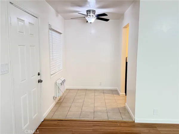 a view of a room with wooden floor and a ceiling fan