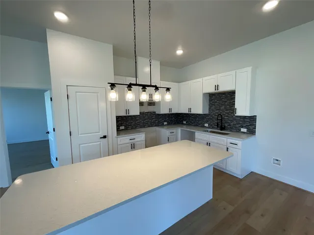 a large kitchen with kitchen island a sink stainless steel appliances and cabinets