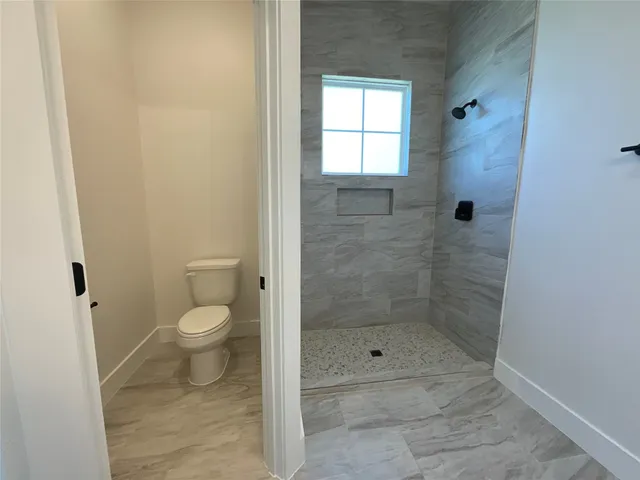 a bathroom with a toilet and a shower