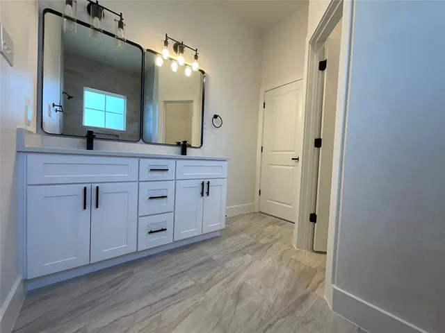 a spacious bathroom with a double vanity sink and mirror
