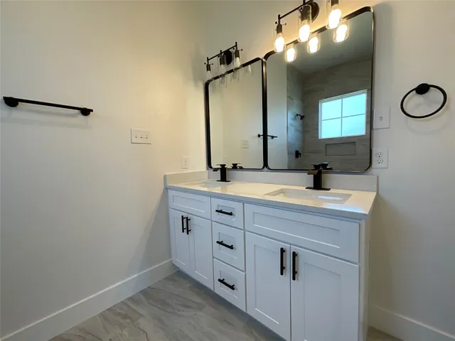 a bathroom with a double vanity sink and mirror