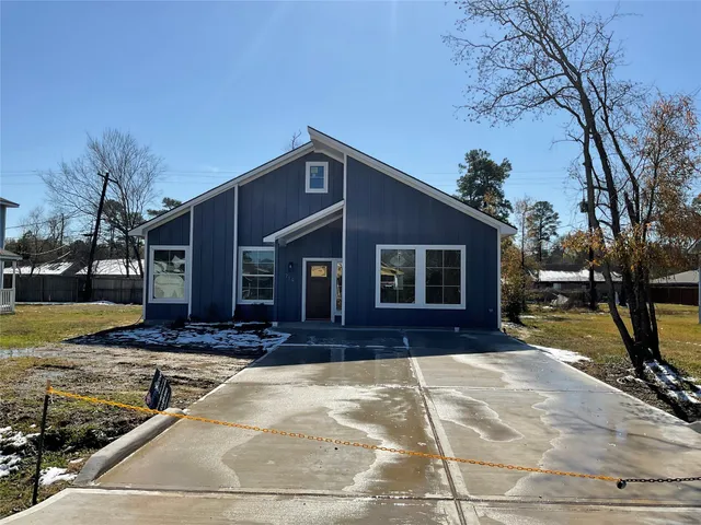 a front view of house with yard and trees in the background